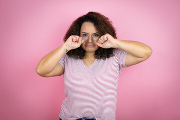 Young african american woman wearing red stripes t-shirt over pink background depressed and worry for distress, crying angry and afraid. Sad expression.
