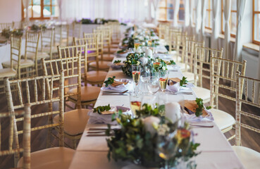 Tables with decoration and plates ready at wedding reception, shallow depth of field photo