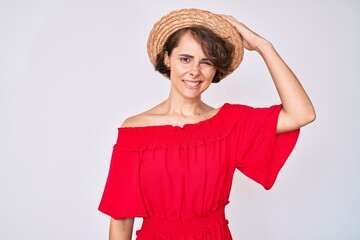 Young hispanic woman wearing summer hat confuse and wonder about question. uncertain with doubt,...