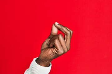 Arm and hand of african american black young man over red isolated background snapping fingers for success, easy and click symbol gesture with hand