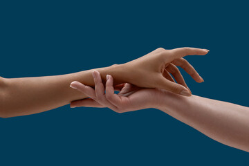 Close up of two women holding arms on each other isolated on blue background