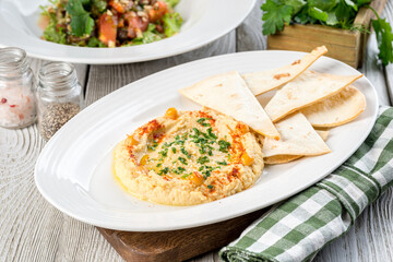 Hummus with tortilla on a white plate