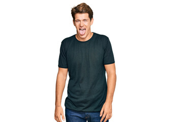 Fototapeta premium Handsome caucasian man wearing casual clothes sticking tongue out happy with funny expression. emotion concept.