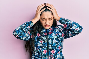 Beautiful middle eastern woman wearing casual floral jacket suffering from headache desperate and stressed because pain and migraine. hands on head.