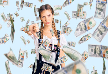 Beautiful caucasian woman with blonde hair wearing octoberfest traditional clothes looking unhappy and angry showing rejection and negative with thumbs down gesture. bad expression.