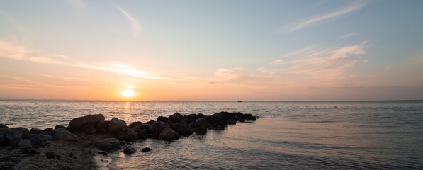 Romantic sea view with small fishing boat at sunset, banner