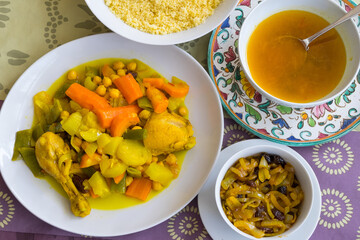Platos con guiso de verduras, caldo y cuscús