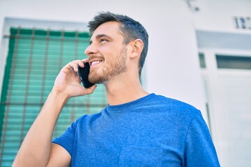 Young caucasian man smiling happy talking on the smartphone at the city.