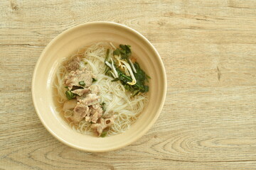 boiled vermicelli thin rice noodles topping  slice braised pork in herb brown soup on bowl
