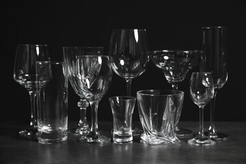 Set of bar glassware on table against dark background