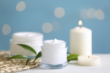 Fototapeta na wymiar Beautiful spa composition with cosmetic products and candles on white table, closeup