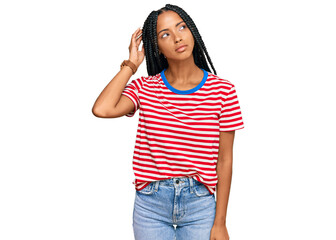 Beautiful hispanic woman wearing casual clothes confuse and wondering about question. uncertain with doubt, thinking with hand on head. pensive concept.