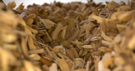 Aromatic brown bark on a light background. Fuel for fireplace. Close-up of wood chips. High quality. 4k footage.