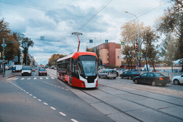 Red and white modern tram on the street in Perm, Russia. New trams for Russian cities. 