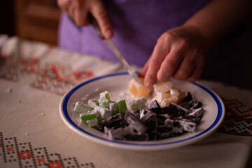 housewife slicing Turkish delicacies into small cubes on a plate