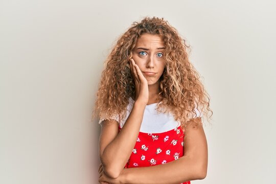 Beautiful caucasian teenager girl wearing red summer dress thinking looking tired and bored with depression problems with crossed arms.