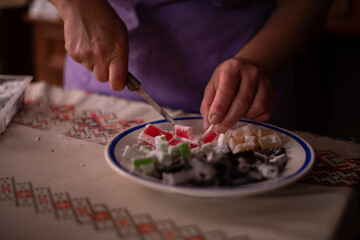 Obraz na płótnie Canvas housewife slicing Turkish delicacies into small cubes on a plate