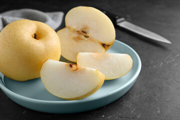 Naklejka na ściany i meble Cut and whole apple pears on black table, closeup