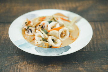 Tom Yam with squid, kaffir lime leaves, galangal, coriander leaves, straw mushrooms.