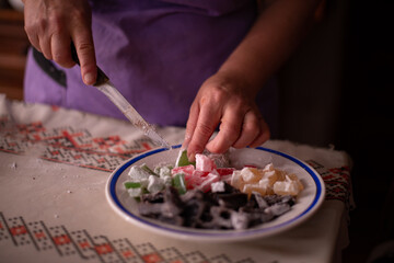 Obraz na płótnie Canvas housewife slicing Turkish delicacies into small cubes on a plate