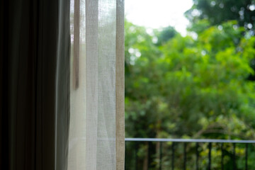 Naklejka premium Transparent white curtain with garden view background in morning