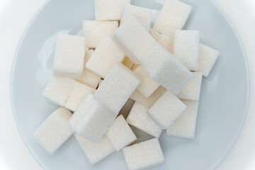 refined sugar sweets calories on a plate light background