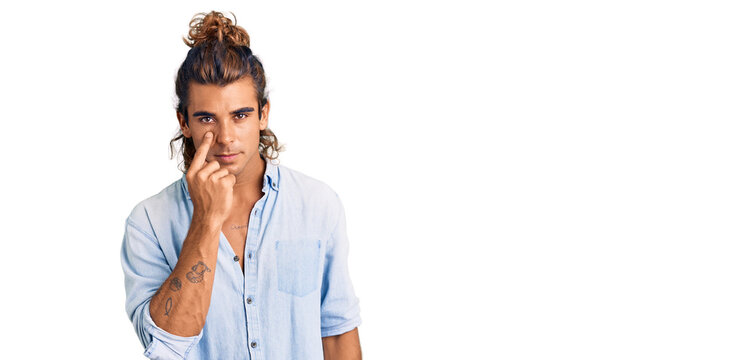 Young hispanic man wearing summer style pointing to the eye watching you gesture, suspicious expression