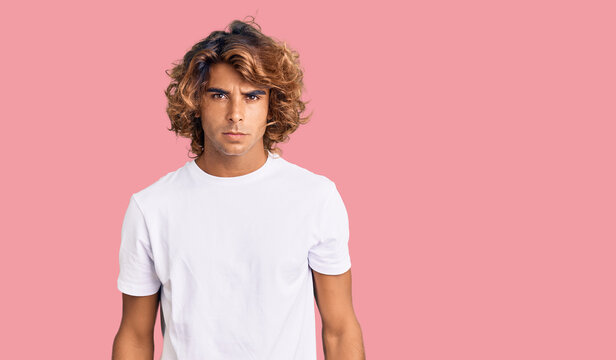 Young hispanic man wearing casual white tshirt skeptic and nervous, frowning upset because of problem. negative person.