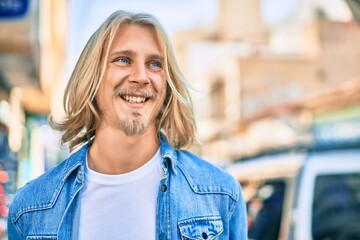 Young blond scandinavian man smiling happy standing at the city.