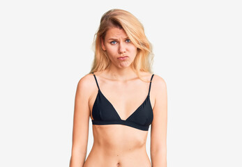 Obraz premium Young beautiful blonde woman wearing bikini depressed and worry for distress, crying angry and afraid. sad expression.