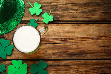 Beer and St Patrick's Day decor on wooden table, flat lay. Space for text