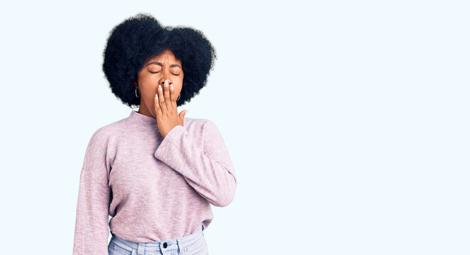 Young african american girl wearing casual clothes bored yawning tired covering mouth with hand. restless and sleepiness.