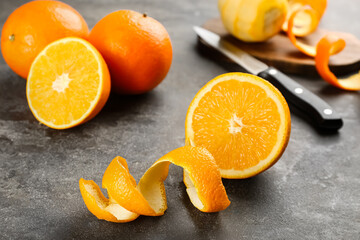 Orange fruits with peel on grey table