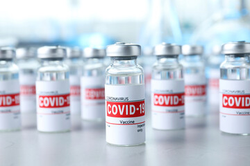 Glass vials with COVID-19 vaccine on light table