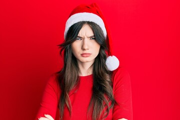 Young beautiful caucasian girl wearing christmas hat skeptic and nervous, disapproving expression on face with crossed arms. negative person.