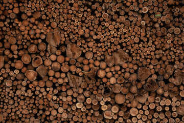 Background of cut wood logs stacked in a pile. wood for the production of chipboard