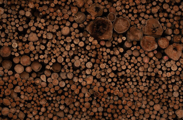 Background of cut wood logs stacked in a pile. wood for the production of chipboard