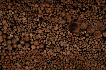 Background of cut wood logs stacked in a pile. wood for the production of chipboard