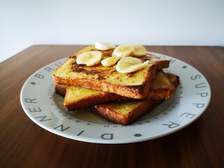 Homemade sweet breakfast. Bread with banana and syrup. Best Dessert to enjoy. Tasty morning breakfast. Close up of food in the kitchen. Isolated on white background