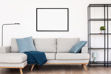 Blank picture frame mockup on white wall. White living room design. View of modern scandinavian...