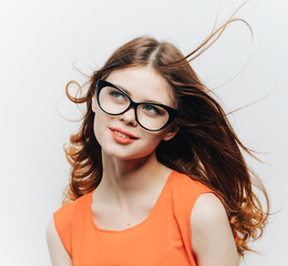 Obraz premium attractive woman with loose hair and glasses and an orange sundress