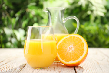 Glassware of fresh orange juice on white wooden table