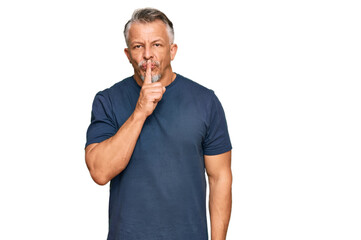 Middle age grey-haired man wearing casual clothes asking to be quiet with finger on lips. silence and secret concept.