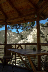 Tree cafe with wooden tables and chairs on a pine tree in the mountains with panoramic views of the mountain area and the forest