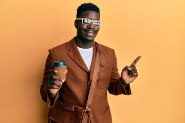 Handsome black man wearing business bag and drinking coffee smiling happy pointing with hand and finger to the side