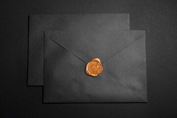 Envelopes with wax seal on black background, top view