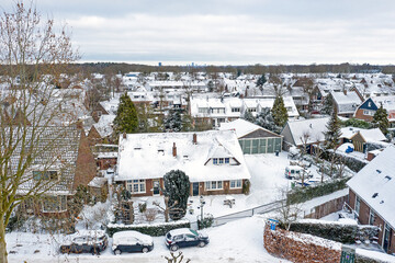 Aerial from snowy town Huizen in the Netherlands in winter