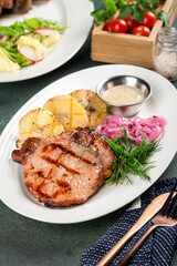 Cooked grilled pork entrecote in a white plate filmed for the menu