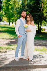 Naklejka premium Groom in a blue suit and bride in an elegant white dress with a bouquet calla 