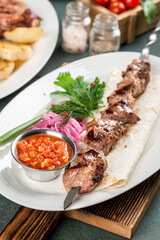 Pork shashlik with sauce and flatbread close-up